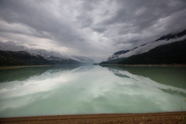 Kanada 'daki dağ gölünün sakin sularındaki kayaların yansımasıyla sakin bir manzara..