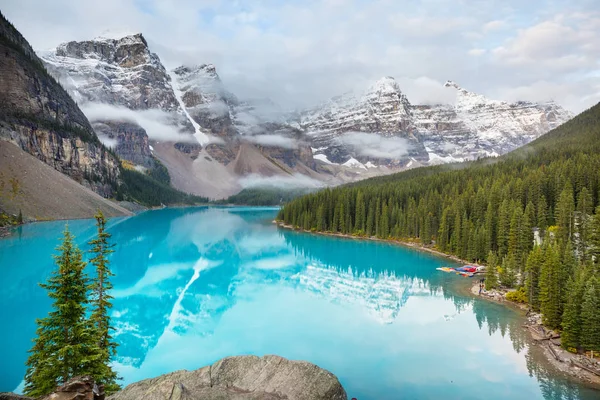 Moraine Gölü 'nün turkuaz suları. Kanada' nın Banff Ulusal Parkı 'nda karla kaplı tepeleri var.