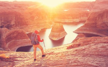 Alışılmadık doğal bir geçmiş. ABD, Utah, Powell Gölü 'ndeki yansıma kanyonu. Güzel gün batımı noktasında dinlenen ilham verici sahne adamı..