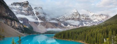 Moraine Gölü 'nün turkuaz suları. Kanada' nın Banff Ulusal Parkı 'nda karla kaplı tepeleri var.