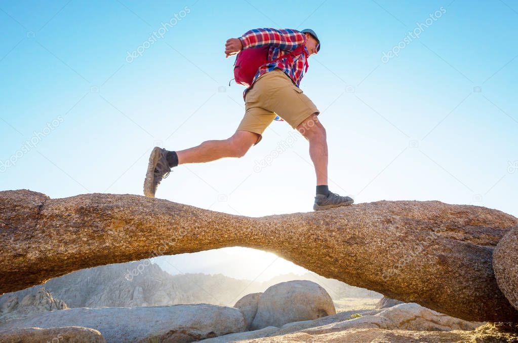 Hiker in unusual stone formations in Alabama hills, California, USA