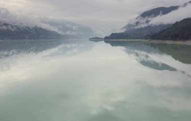 Kanada 'daki dağ gölünün sakin sularındaki kayaların yansımasıyla sakin bir manzara..