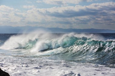 Kumsalda mavi dalga. Bulanık arkaplan ve güneş ışığı lekeleri. Huzurlu doğal arkaplan.