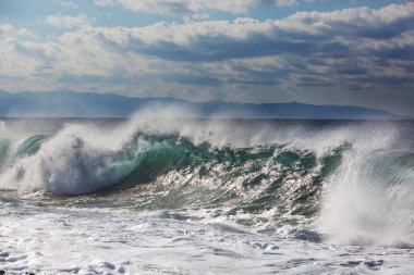 Kumsalda mavi dalga. Bulanık arkaplan ve güneş ışığı lekeleri. Huzurlu doğal arkaplan.