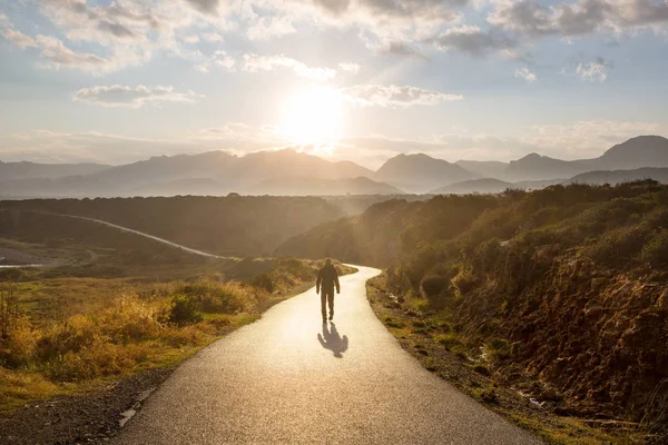Malerische Straße Den Bergen Reisehintergrund Mann Geht Auf Sonnenaufgang Hintergrund — Stockfoto