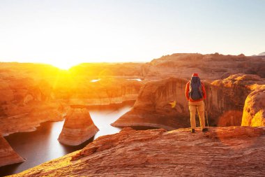 Alışılmadık doğal bir geçmiş. ABD, Utah, Powell Gölü 'ndeki yansıma kanyonu. Güzel gün batımı noktasında dinlenen ilham verici sahne adamı..