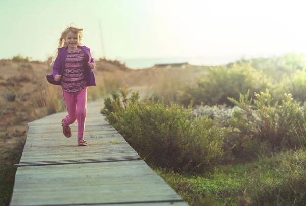 Kleines Mädchen Läuft Bei Sonnenaufgang Über Strandpromenade Meer — Stockfoto