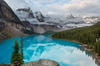 Moraine Gölü 'nün turkuaz suları. Kanada' nın Banff Ulusal Parkı 'nda karla kaplı tepeleri var.