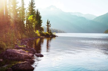 Kanada 'daki dağ gölünün sakin sularındaki kayaların yansımasıyla sakin bir manzara..
