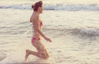 Kız deniz dalgasında zıplıyor