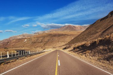 Dağlarda manzaralı bir yol. Seyahat geçmişi. Gündoğumu arka planında giden adam.