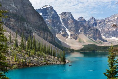 Moraine Gölü 'nün turkuaz suları. Kanada' nın Banff Ulusal Parkı 'nda karla kaplı tepeleri var.