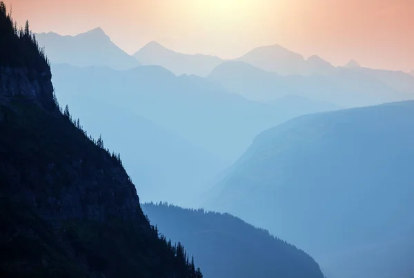 Misty mountain silhouette at sunrise