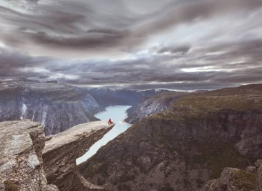 Norveç, Trolltunga uçurumunda oturan bir yürüyüşçü.