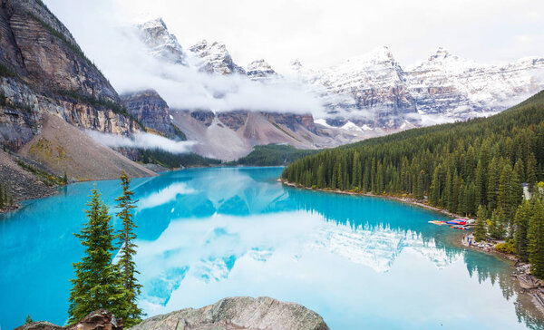 Beautiful turquoise waters of the Moraine lake with snow-covered peaks above it in Banff National Park of Canada