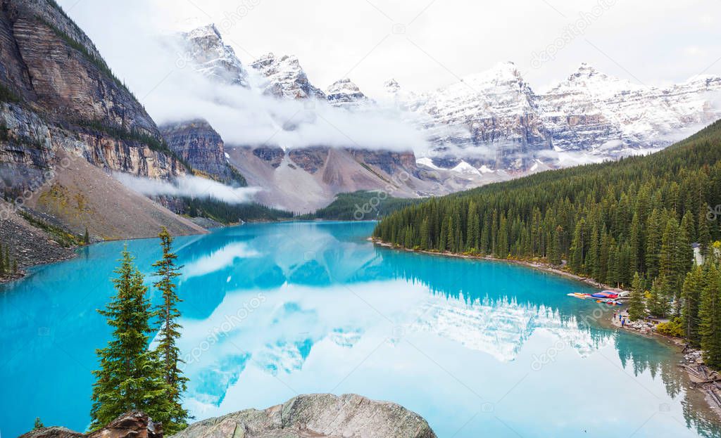 Beautiful turquoise waters of the Moraine lake with snow-covered peaks above it in Banff National Park of Canada