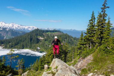Yaz tatillerinde dağlarda yürüyüş yapan aktif yaşam tarzı macera tatili yapan bir adam. Yürüyüş konsepti
