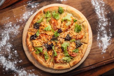 Sezar pizza dağınık ahşap arka plan üzerinde.