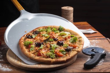 Sezar pizza dağınık ahşap arka plan üzerinde.