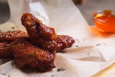 Baharatlı ekşi soslu tavuk kanadı kağıt üzerinde hizmet