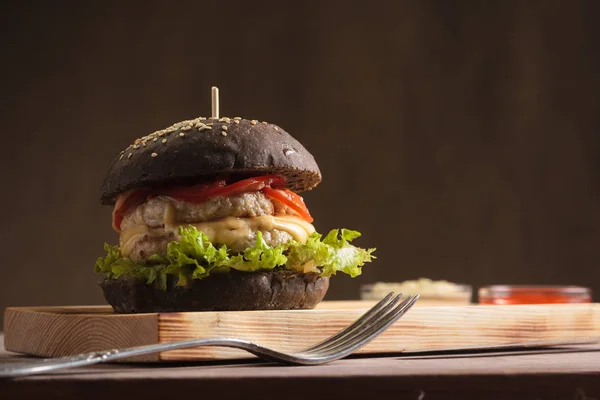 Módní hamburger s kuřecím masem v černé housce — Stock fotografie