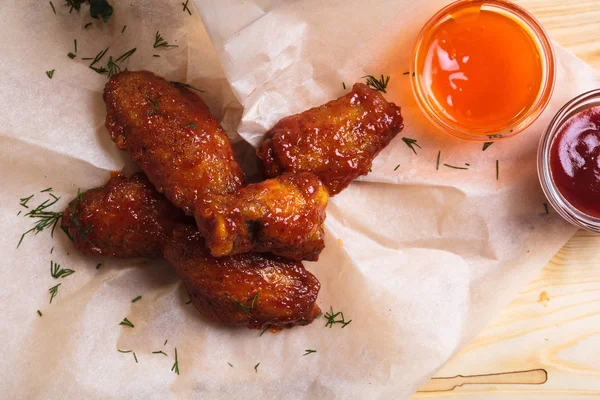 Asas de frango em molho azedo picante servido em papel — Fotografia de Stock