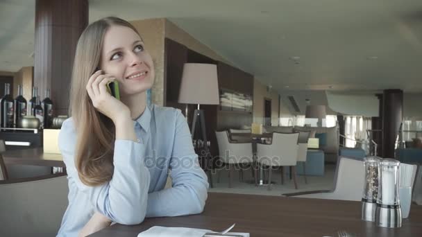 Chica comprobar y hablar en un teléfono por la ventana — Vídeo de stock