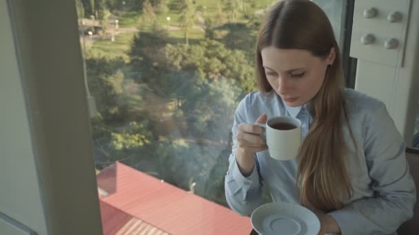 Chica beber té por la ventana del restaurante de moda — Vídeo de stock