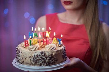 Stil kız pasta mumlar ile tutarak renkli ışıklı sahnede ayakta kadar güzel genç vintage PIN.