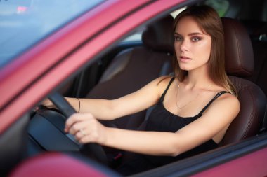 Alacakaranlık bir arabada oturup güzel ciddi kız