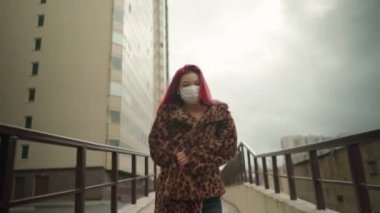 Güzel Asyalı kız, siyah saçlı, maske takan, caddede yürüyen..