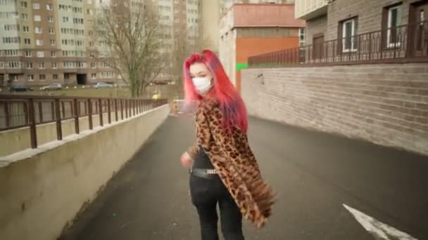 Beautiful young asian girl with colored hair in medical mask walk street. — Stock Video