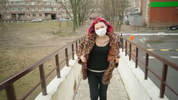 Mooi jong aziatisch meisje met gekleurd haar in medisch masker lopen straat. — Stockvideo