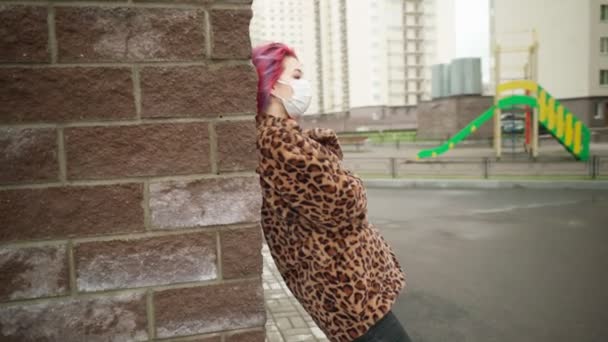 Beautiful young asian girl with colored hair in medical mask standing street — Stock Video