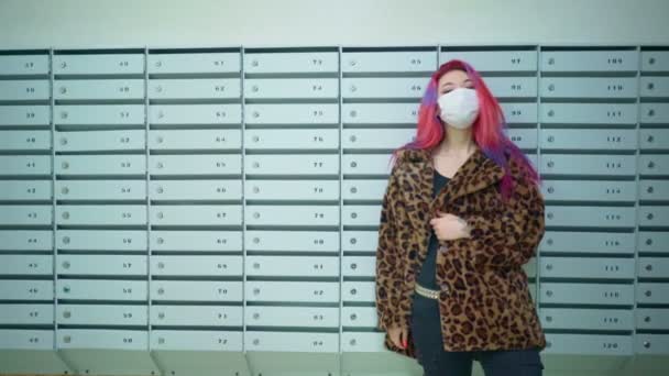 Beautiful young asian girl colored hair medical mask near mailboxes — Stock Video