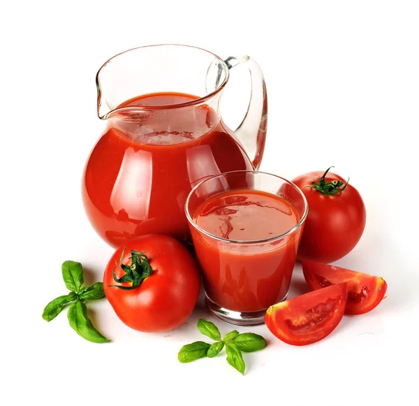 Džbán, sklenice rajčatové šťávy a ovoce se zelenými listy — Stock fotografie