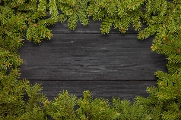 Evergreen grenar på svart bord — Stockfoto