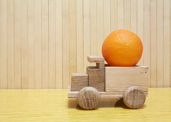 Toy wooden car with orange — Stockfoto