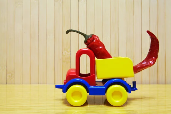 Toy plastic car with red pepper — Stockfoto