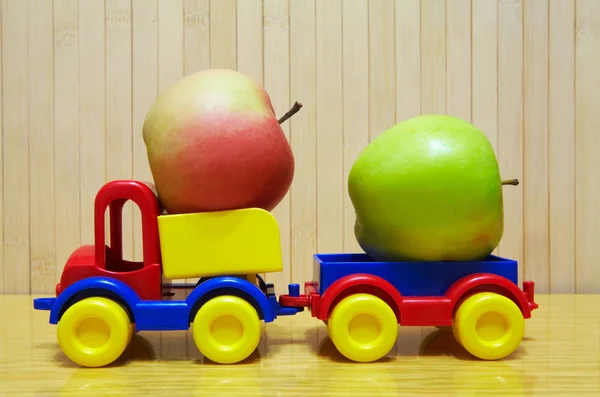 Toy plastic car with apple — Stockfoto