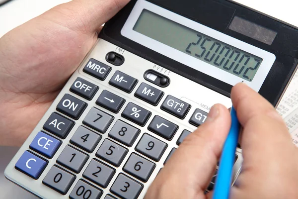 Hombre de negocios con calculadora en la oficina — Foto de Stock