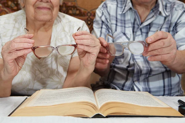 An elderly couple reading a book — Stock Photo, Image
