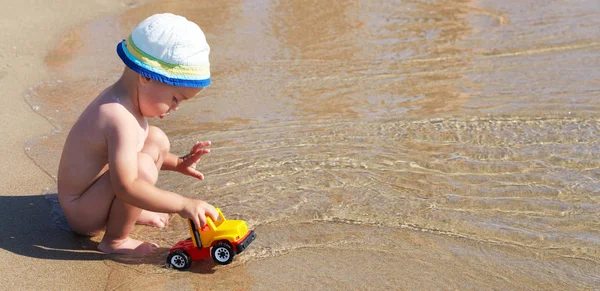 Маленький мальчик играет в воде в море — стоковое фото