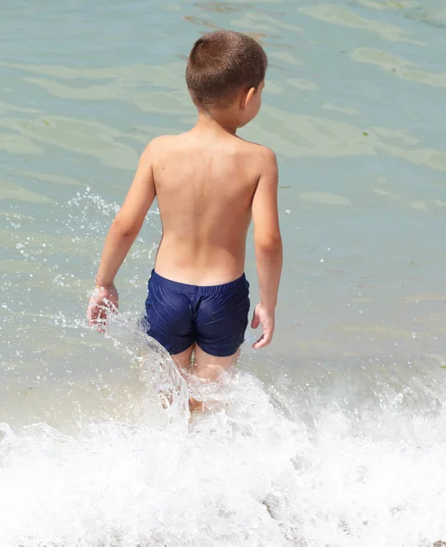 Petit garçon joue dans la mer — Photo
