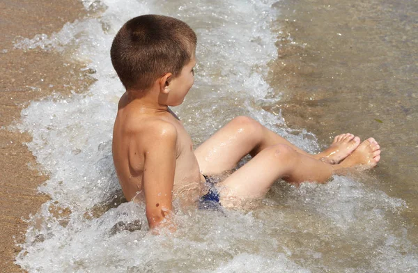 Petit garçon joue dans la mer — Photo