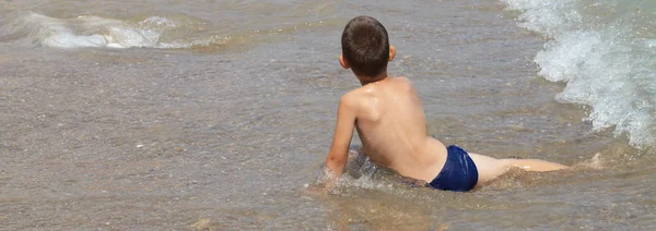 Liten pojke leker i havet — Stockfoto