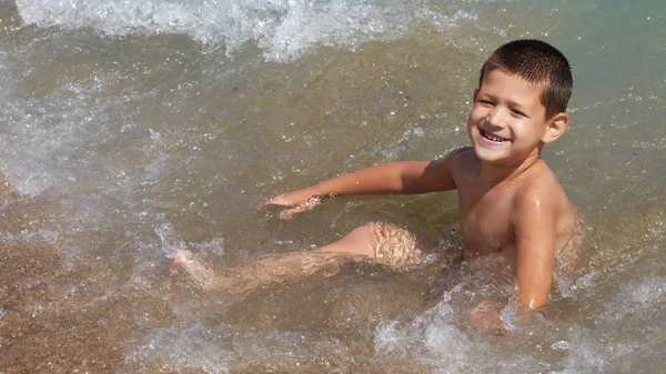 Маленький мальчик играет в море — стоковое фото