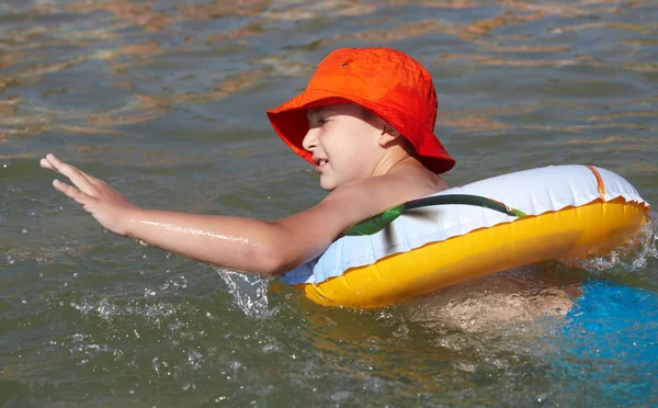 Garçon joué dans la mer avec anneau en caoutchouc — Photo