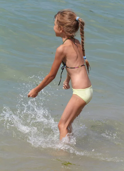 Маленькая девочка играет в море — стоковое фото