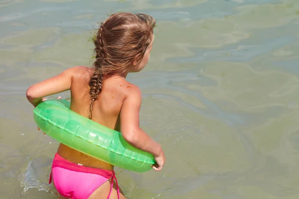 Klein meisje speelde in de zee met Rubberring — Stockfoto